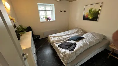 a small bedroom with a bed in a room at Staudeengen et dejlig sted med fred og ro in Ålestrup