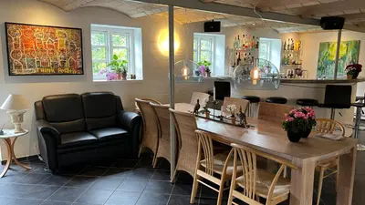 a dining room with a table and chairs at Staudeengen et dejlig sted med fred og ro in Ålestrup