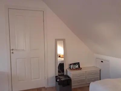 a bedroom with a white door and a mirror at Hytten in Frøstrup