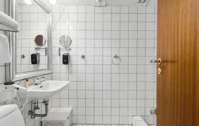 a white bathroom with a sink and a mirror at Lejl 6 in Brovst
