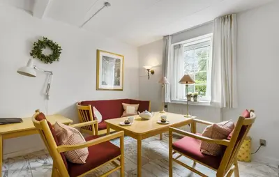 a living room with a table and chairs and a couch at Lejl 6 in Brovst