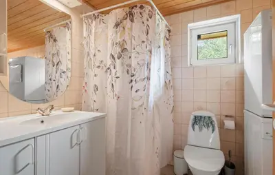 a bathroom with a toilet and a shower curtain at Stunning Home In Brovst With Sauna in Brovst