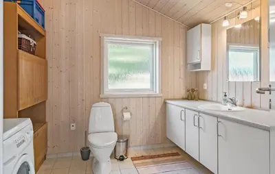 a bathroom with a toilet and a sink and a window at 3 Bedroom Stunning Home In Løgstrup in Løgstrup