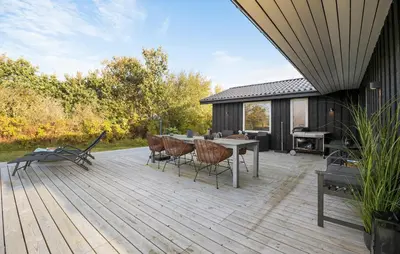a wooden deck with a table and chairs on it at Awesome Home In Løgstør With Wifi in Løgstør
