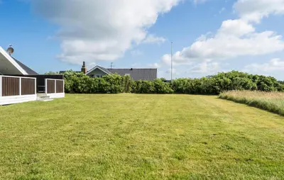 a large grassy yard with a house at Cozy Home In Harboøre in Harboør