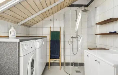 a bathroom with a washing machine and a sink at Cozy Home In Harboøre in Harboør