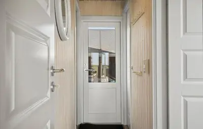 a white door with a window in a hallway at Cozy Home In Harboøre in Harboør