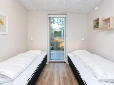 two beds in a room with a sliding glass door at 5 star holiday home in Vestervig-By Traum in Vestervig