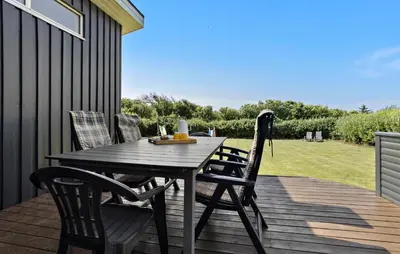 a wooden deck with a table and chairs on it at Lovely Home In Vestervig With Kitchen in Vestervig