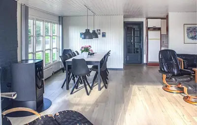 a dining room with a table and black chairs at Lovely Home In Vestervig With Kitchen in Vestervig