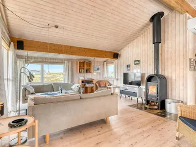 a living room with a couch and a fireplace at Holiday Home Hughe - 200m from the sea by Interhome in Frøstrup