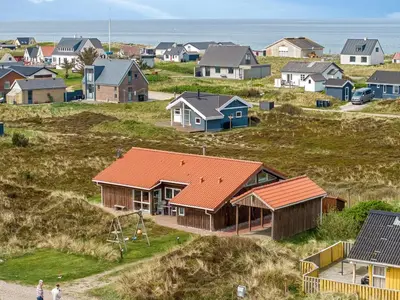 a group of houses on a hill next to the ocean at Holiday Home Hughe - 200m from the sea by Interhome in Frøstrup