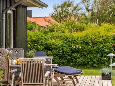 a patio with chairs and a table with a blue cushion at Holiday Home Gedda - from the sea by Interhome in Vestervig
