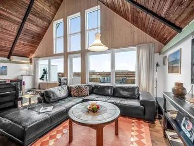 a living room with a leather couch and a table at Holiday Home Luzy - 75m from the sea by Interhome in Harboør