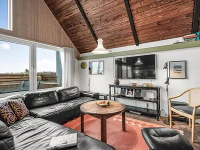 a living room with a couch and a table at Holiday Home Luzy - 75m from the sea by Interhome in Harboør