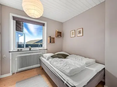 a bedroom with a bed and a window at Holiday Home Hilppa - 400m from the sea by Interhome in Harboør