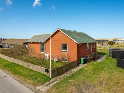 a house with a fence in front of it at Holiday Home Hilppa - 400m from the sea by Interhome in Harboør