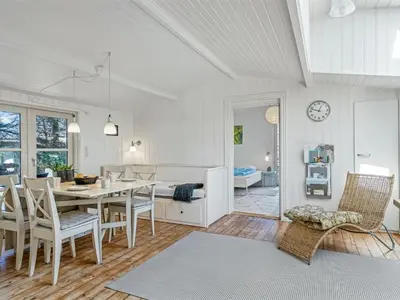 a kitchen and dining room with a table and chairs at Holiday Home Hellena - 700m from the sea by Interhome in Torsted