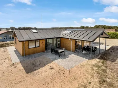 a house with a metal roof on top of a field at Holiday Home Helga - 650m from the sea by Interhome in Torsted