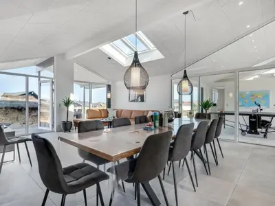 a dining room and living room with a table and chairs at Holiday Home Helga - 650m from the sea by Interhome in Torsted