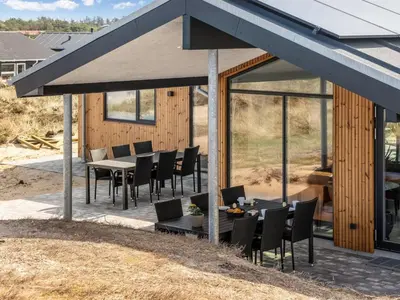 a patio with black chairs and tables and a building at Holiday Home Helga - 650m from the sea by Interhome in Torsted