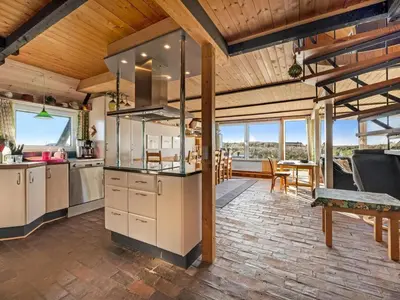 a kitchen with wooden ceilings and a dining room at Holiday Home Kurt - 75m from the sea by Interhome in Harboør