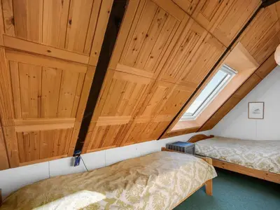 two beds in a room with wooden ceilings at Holiday Home Kurt - 75m from the sea by Interhome in Harboør