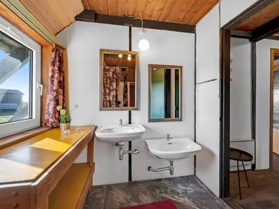 a bathroom with two sinks and a mirror at Holiday Home Kurt - 75m from the sea by Interhome in Harboør
