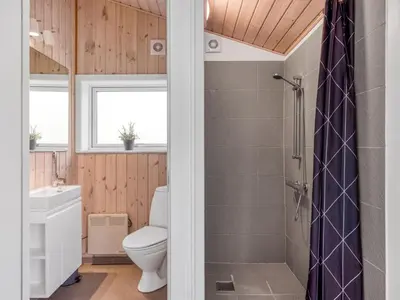 a bathroom with a toilet and a sink and a shower at Holiday Home Yngve - 1-2km from the sea by Interhome in Løkken