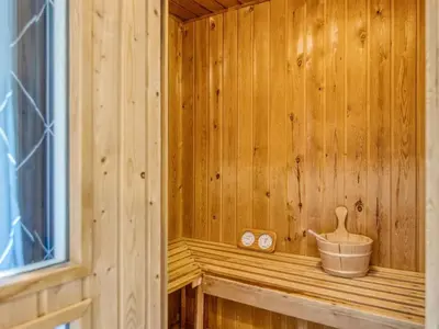 a wooden sauna with a bucket on a ledge at Holiday Home Yngve - 1-2km from the sea by Interhome in Løkken