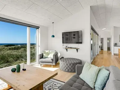 a living room with a couch and a table at Holiday Home Carit - 450m from the sea by Interhome in Løkken