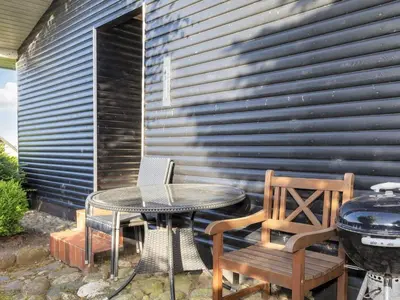 a patio with a table and chairs and a grill at 5 person holiday home in Roslev-By Traum in Roslev