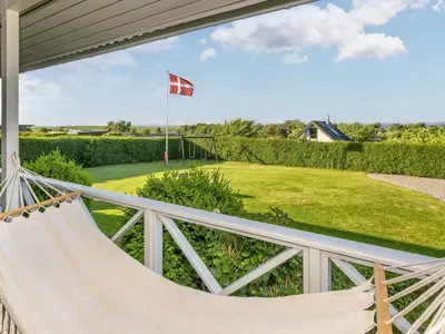 a hammock on a porch with a flag at 5 person holiday home in Roslev-By Traum in Roslev