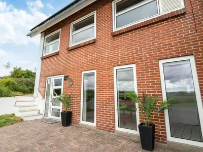 a brick house with two potted plants in front of it at Family Fun with Fjord View - By Traum Ferienwohnungen in Thyholm
