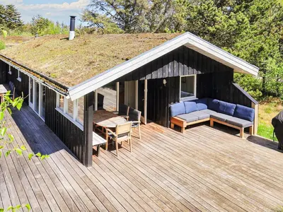 a house with a roof with a couch on a deck at 8 person holiday home in Pandrup-By Traum in Pandrup