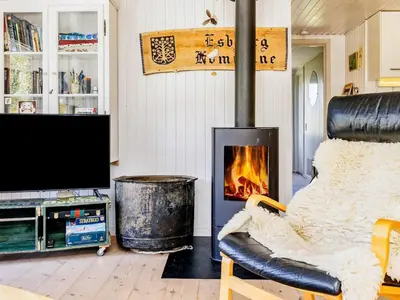 a living room with a fireplace and a tv at 8 person holiday home in Pandrup-By Traum in Pandrup