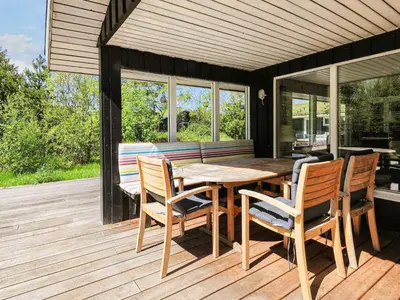 a wooden deck with a wooden table and chairs at 8 person holiday home in Pandrup-By Traum in Pandrup