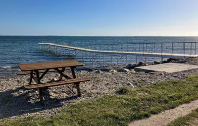 a picnic table sitting on the beach near the ocean at 3 Bedroom Awesome Home In Hurup Thy in Sønder Ydby