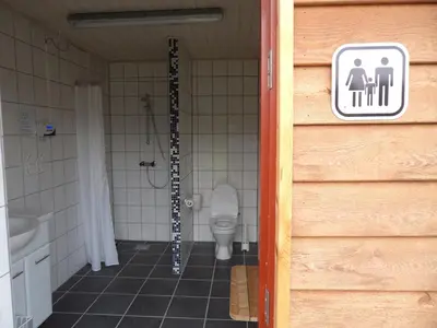 a bathroom with a toilet and a sign on the door at Hedelandets Camping in Sevel