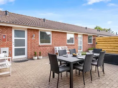 a patio with a table and chairs in front of a house at Holiday Home Sulo - 300m from the sea by Interhome in Blokhus