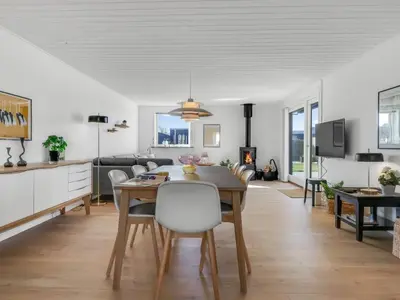 a kitchen and living room with a table and chairs at Holiday Home Sulo - 300m from the sea by Interhome in Blokhus