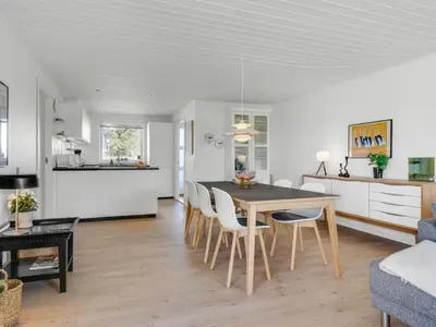 a dining room and living room with a table and chairs at Holiday Home Sulo - 300m from the sea by Interhome in Blokhus