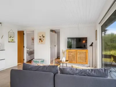 a living room with a couch and a tv at Holiday Home Mintha - 400m from the sea by Interhome in Blokhus