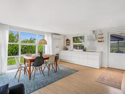 a kitchen and dining room with a table and chairs at Holiday Home Mintha - 400m from the sea by Interhome in Blokhus