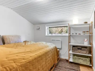 a bedroom with a large bed and a window at Holiday Home Jenvold - 1-5km from the sea by Interhome in Blokhus
