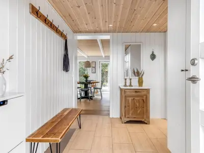 a hallway with a wooden bench in a house at Holiday Home Jenvold - 1-5km from the sea by Interhome in Blokhus