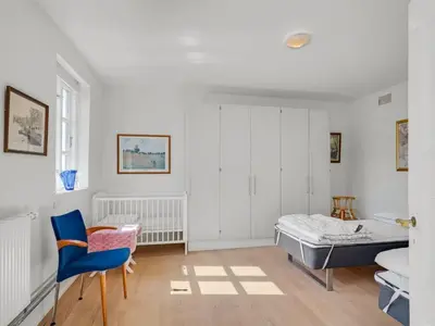 a bedroom with a bed and a blue chair at Holiday Home Ejnarine - 600m to the fjord by Interhome in Farsø