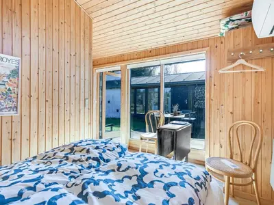 a bedroom with a bed and a sliding glass door at Holiday Home Amarie - 1km from the sea by Interhome in Pandrup