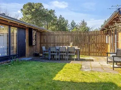 a patio with a table and chairs and a fence at Holiday Home Amarie - 1km from the sea by Interhome in Pandrup