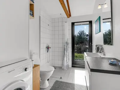a white bathroom with a toilet and a sink at Holiday Home Amarie - 1km from the sea by Interhome in Pandrup